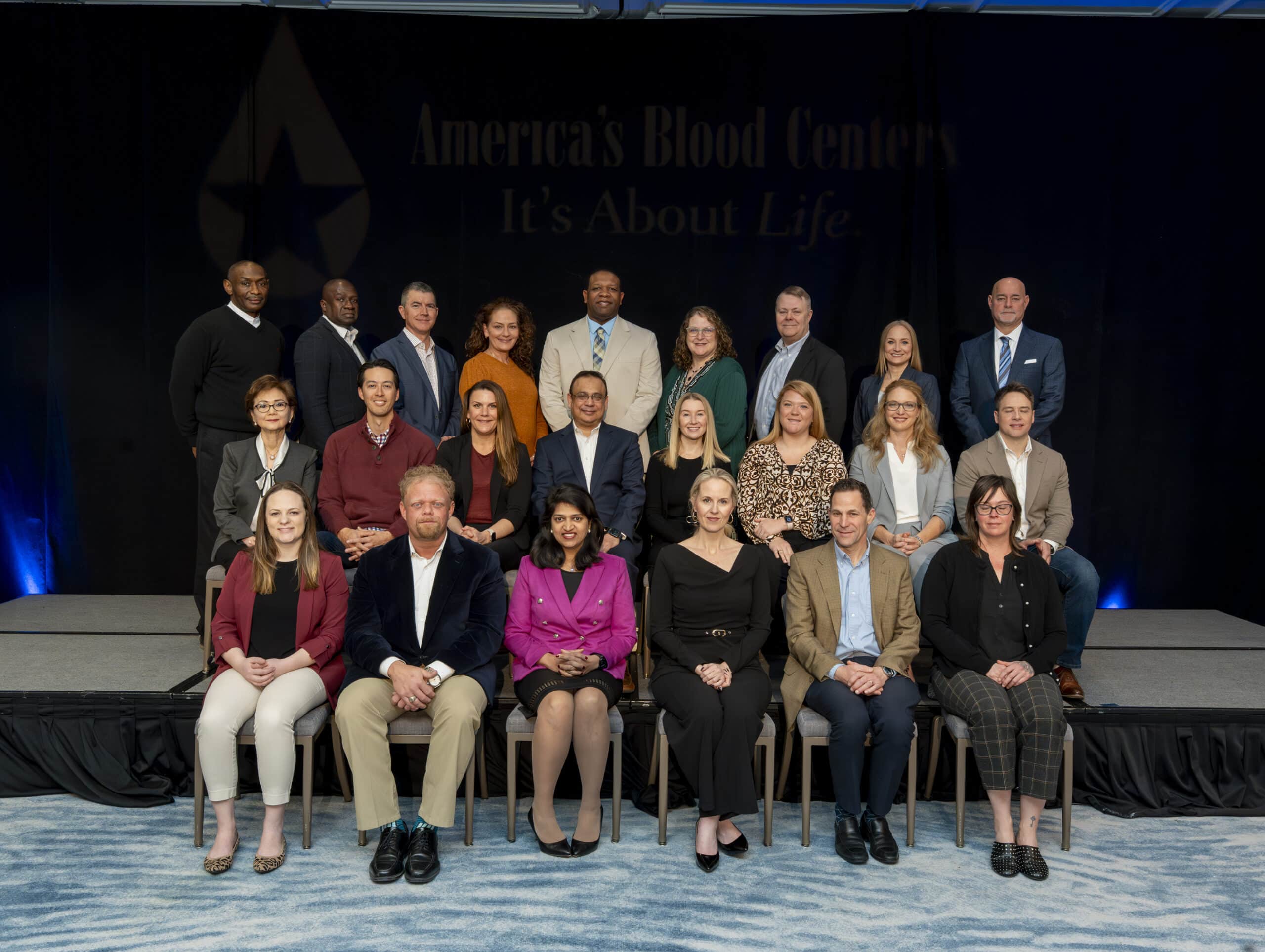 Picture of the entire executive fellows' program participants lined up on a stage together.
