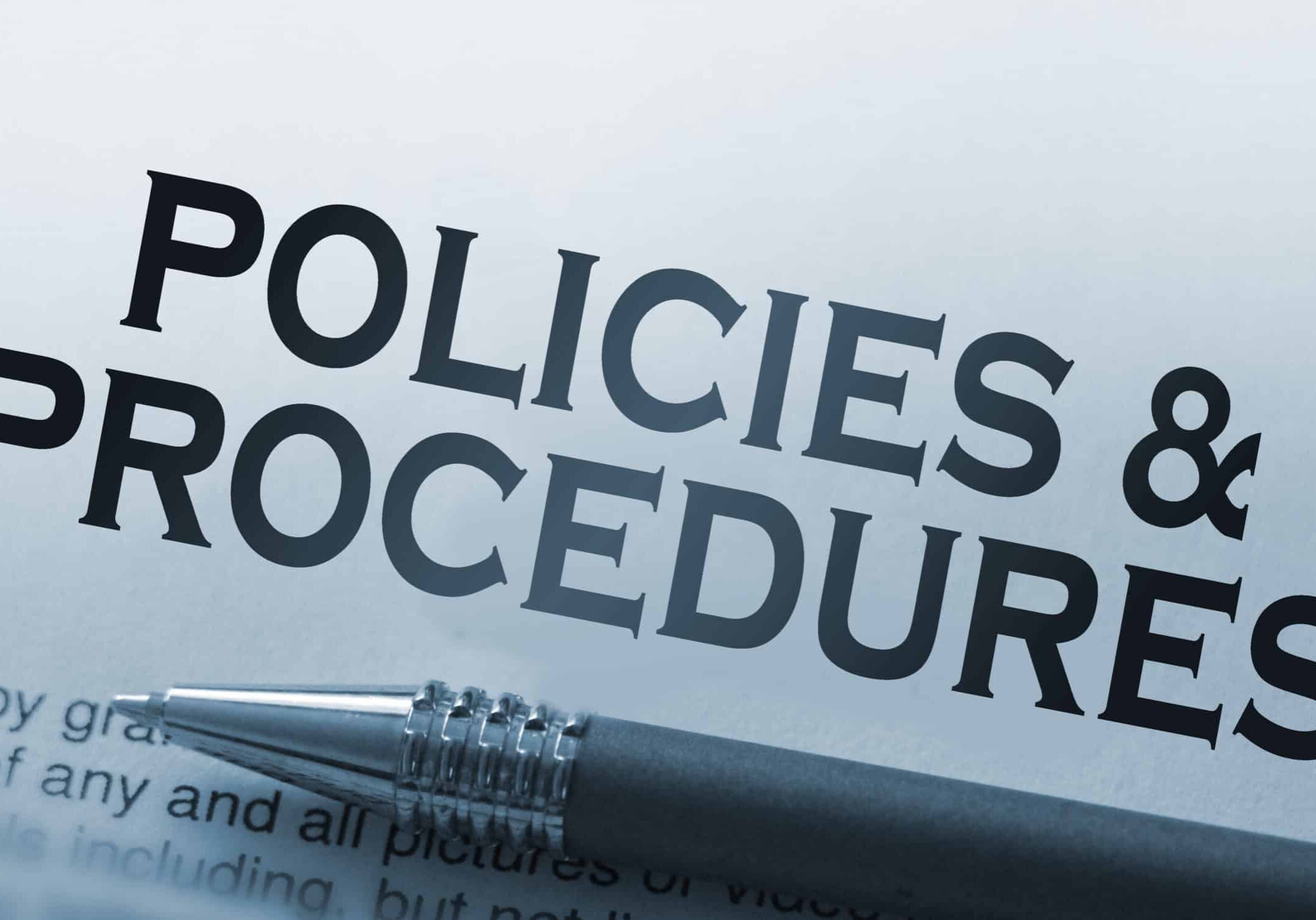 Policies and procedures memo typed on a notebook with pen. Business rules concept.